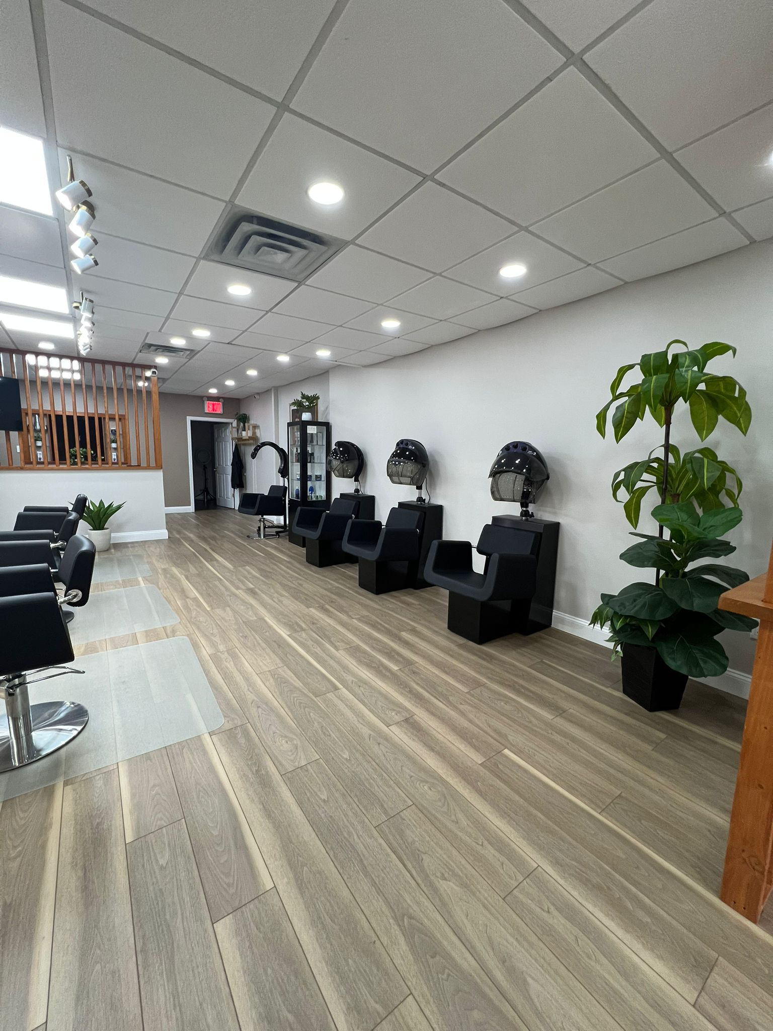 Salon floor with dryers lined along the wall and bright lighting